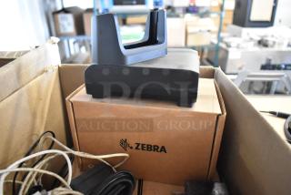 Brand new Zebra docking unit with wires, in box. Logo visible. Ideal for multiple connectivity needs.