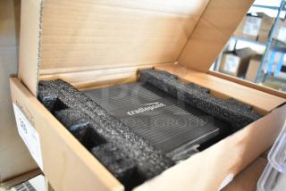 Brand new Cradlepoint router in original packaging, secured with foam padding, showcasing logo on top.