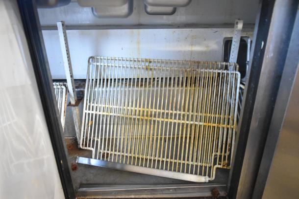 Interior of a True TSSU-72-30M-B-ST prep table showing wire shelves with visible rust and wear in a stainless steel compartment.
