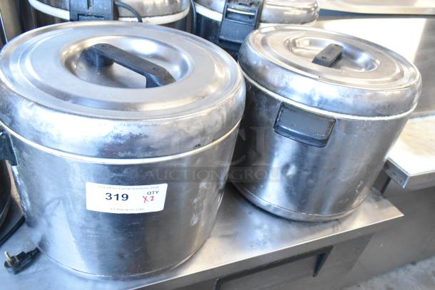 Two metal rice holders with locking lids, visible wear, auction tag labeled "319 QTY X2."