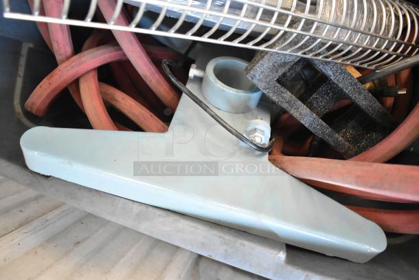 Poly bin containing various items, including red hoses, metal parts, and a wire rack. Items appear used and mixed.