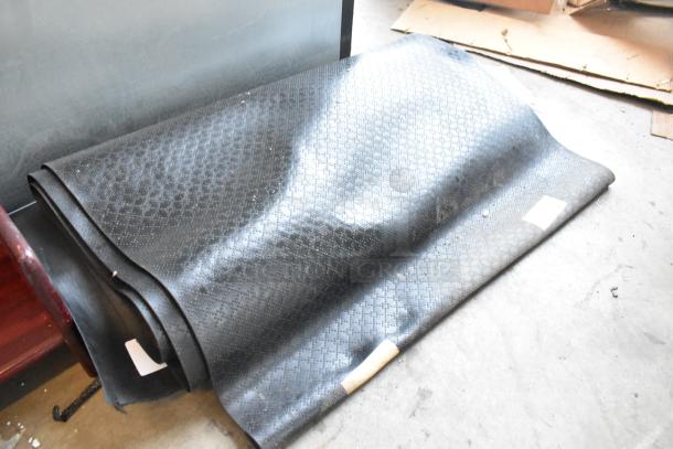 Two brown floor mats featuring a subtle geometric pattern, rolled and stacked, in used condition.