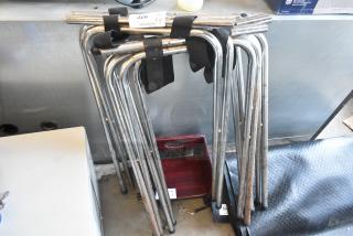 Four metal serving tray stands, stacked and secured with black straps. Slight rust visible, good for catering or events.