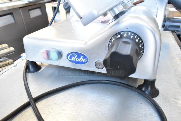 Globe G12 Metal Commercial Meat Slicer with blade sharpener, 115V, 1 phase. Features control dial and visible branding.