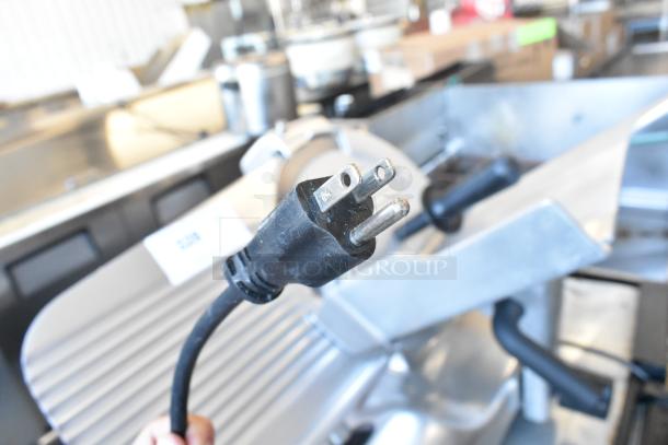 Globe G12 metal commercial countertop meat slicer with blade sharpener, showing power cord plug. 115 volts, 1 phase.