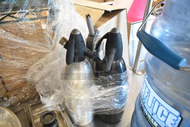 Bundle of kitchen items including San Jamar ice bucket, ricer, mandolin slicer, and whipped cream dispensers wrapped in plastic.