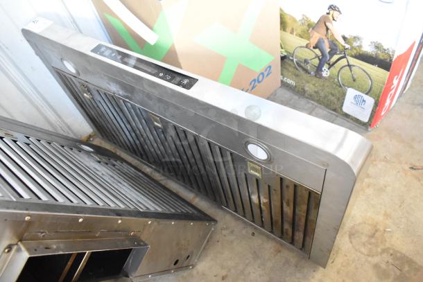 Stainless steel metal range hood with dual filters and control panel. Some visible wear; integrated lights included.