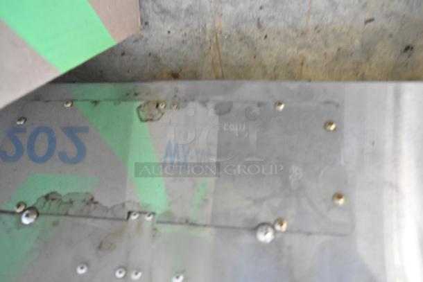 Metal range hood with visible wear and screw fastenings. Markings include "MX-505." Surface shows signs of use.