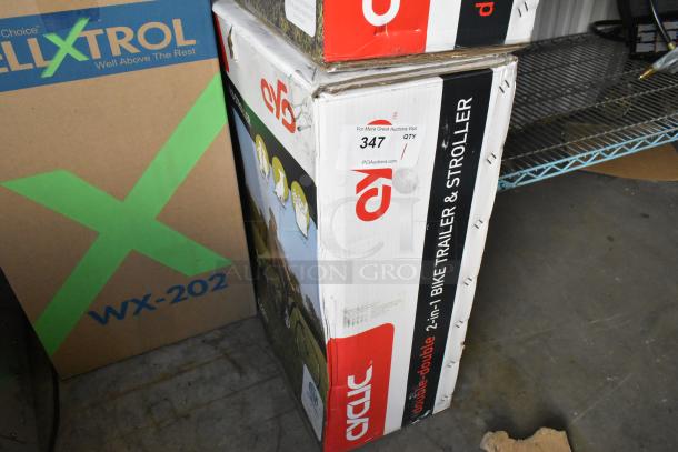 Brand new Cyclic Double 2-in-1 Bike Trailer & Stroller in box, model shown on packaging, auction tag 347 visible.