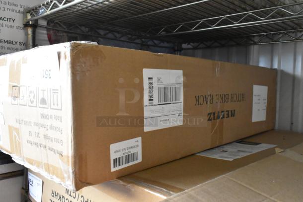 Brown box labeled "Hitch Bike Rack" on shelf, new in packaging. Brand: Meizi. Shipping labels visible.
