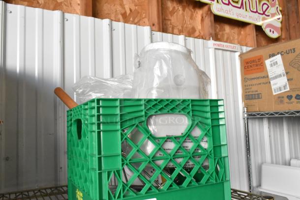 Brand new lot of items in a green crate, featuring a poly container, wrapped in plastic, with visible product labels.