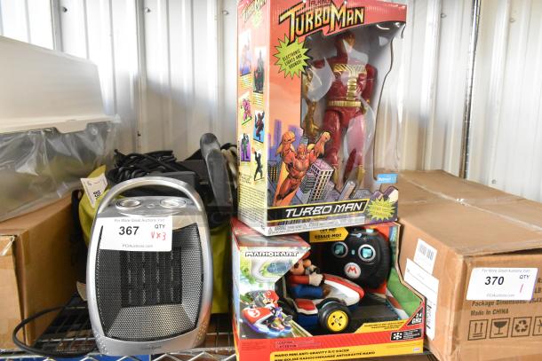 Three brand new items: Turbo Man figurine in box, Mario Kart figurine in box, and GiveBest heater with tag.