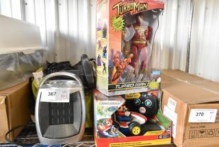Three brand new items: Turbo Man figurine in box, Mario Kart figurine in box, and GiveBest heater with tag.