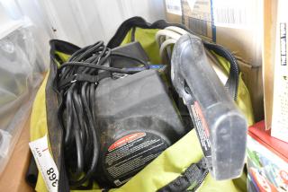 Ryobi 1600 PSI electric pressure washer in a green carrying bag. Shows power cord and warning label. Used condition.