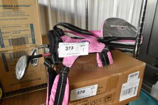 Pink US Kids Golf bag with three clubs, silver accents, good condition. Adjustable straps, branded logo visible on side.