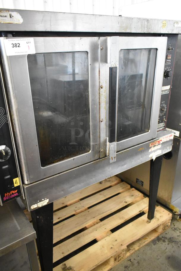 Hobart HGC5-10 stainless steel convection oven with view-through doors, metal racks, thermostatic controls, on metal legs.