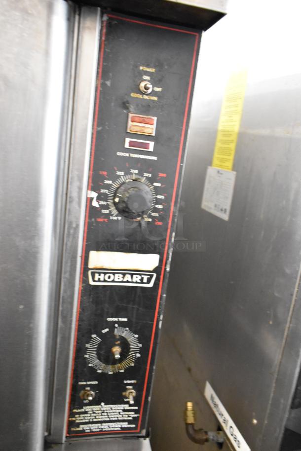Hobart HGC5-10 stainless steel convection oven with thermostatic controls and metal legs, featuring view-through doors and metal racks.
