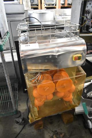 Metal commercial countertop citrus juicer, 115 volts, 1 phase. Includes orange juicing components. Appears in used condition.