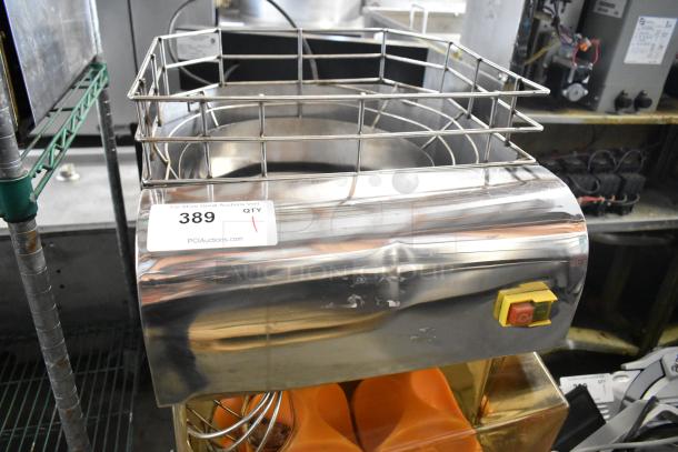 Metal commercial countertop citrus juicer, 115 volts, 1 phase. Features a stainless steel finish with protective guard.