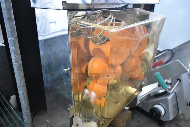 Metal commercial countertop citrus juicer, 115 volts, 1 phase, with visible plastic components in good condition.