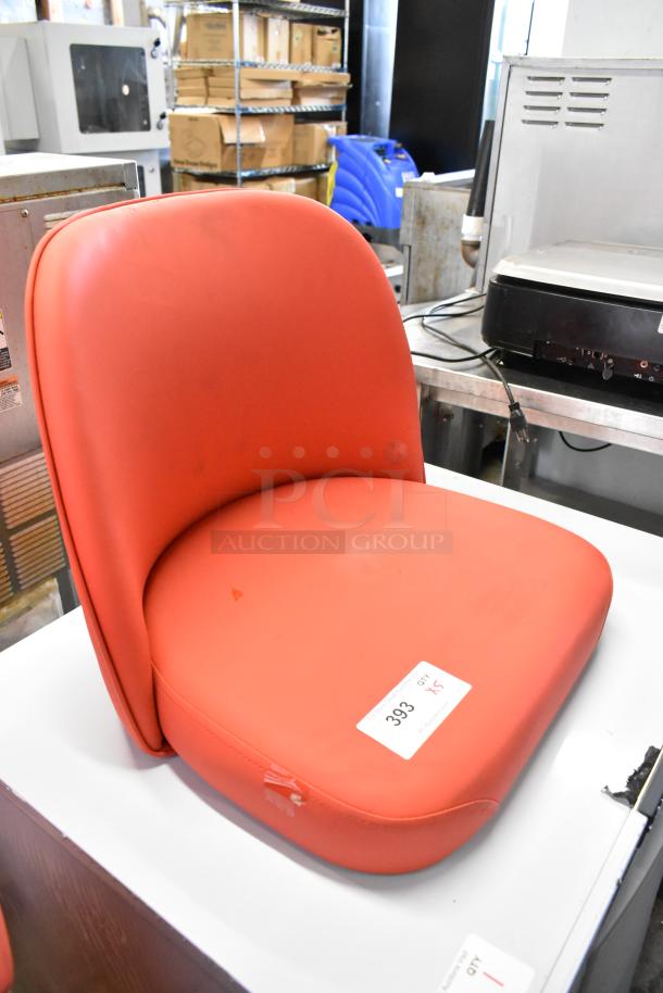 Red bucket seat style stool seat, brand new, no frame. Features smooth red upholstery and a label marked "393."