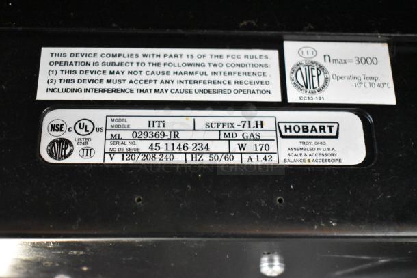 2016 Hobart HTi metal commercial countertop food portioning scale label showing model, serial number, and voltage details.