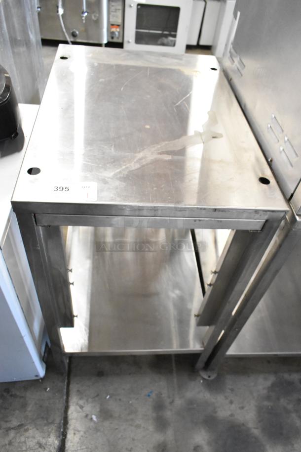 Metal table with under shelf, stainless steel, visible surface wear, auction tag marked "395."