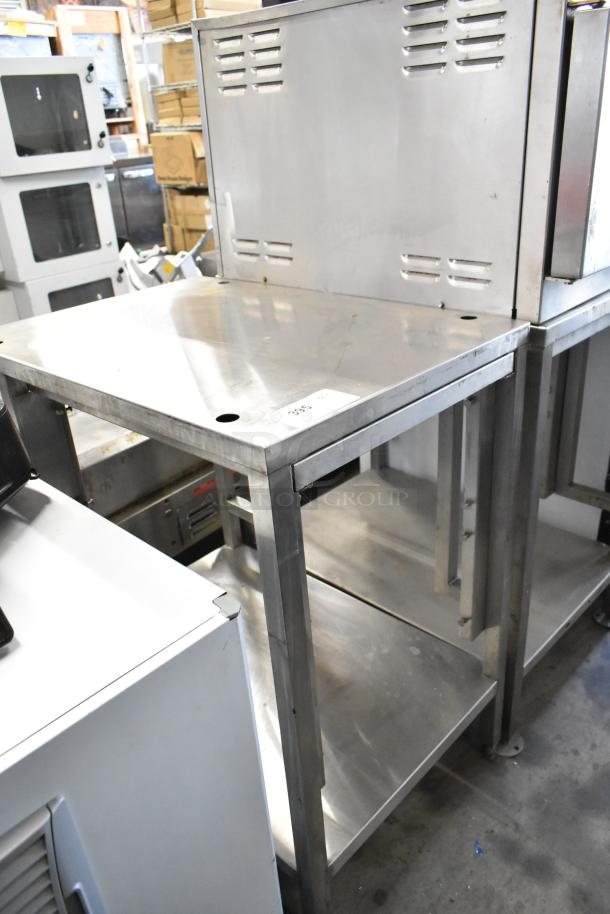 Stainless steel metal table with under shelf, vented backsplash, sturdy condition, slight surface wear, labeled with auction tag 305.