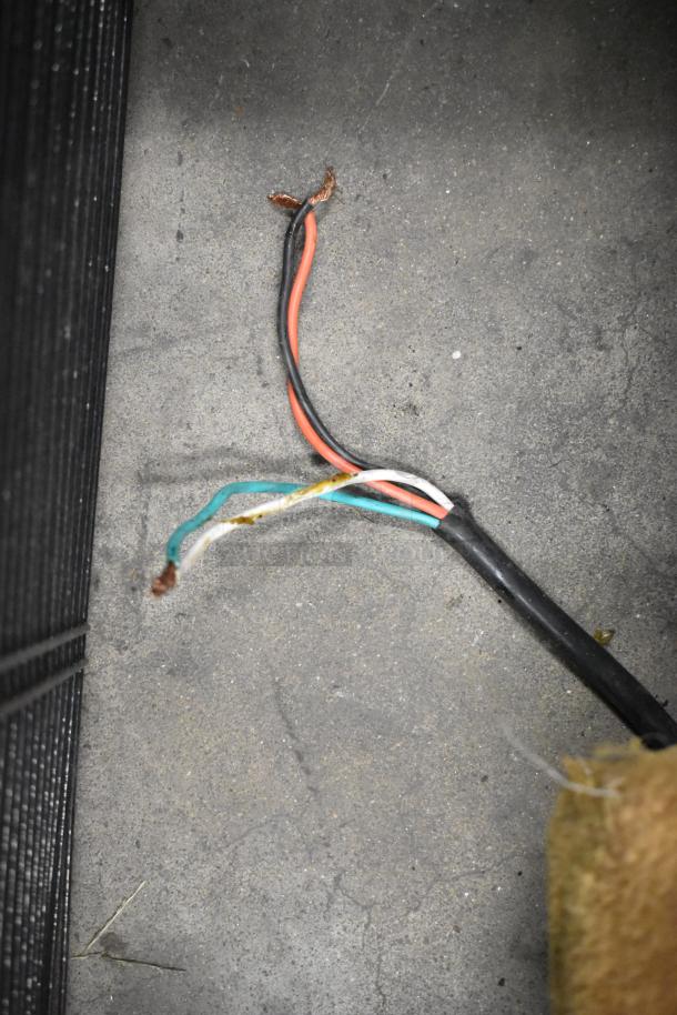 Loose electrical wires on concrete floor, adjacent to black textured surface.