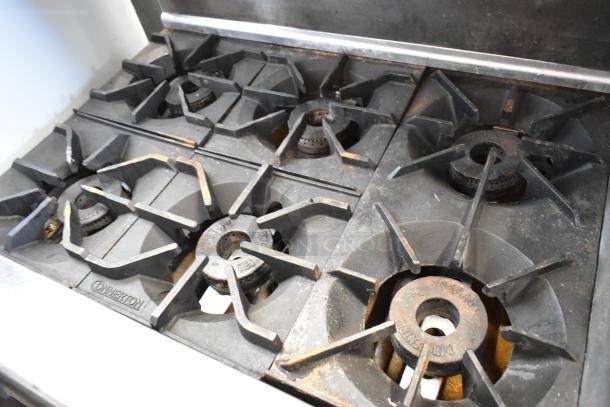 Imperial stainless steel commercial 6-burner gas range with flat top griddle, dual ovens, overshelf, backsplash, on casters.