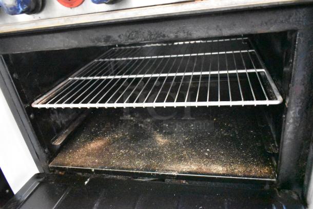 Imperial stainless steel gas 6 burner range with right side flat top griddle, two ovens, over-shelf, and backsplash.