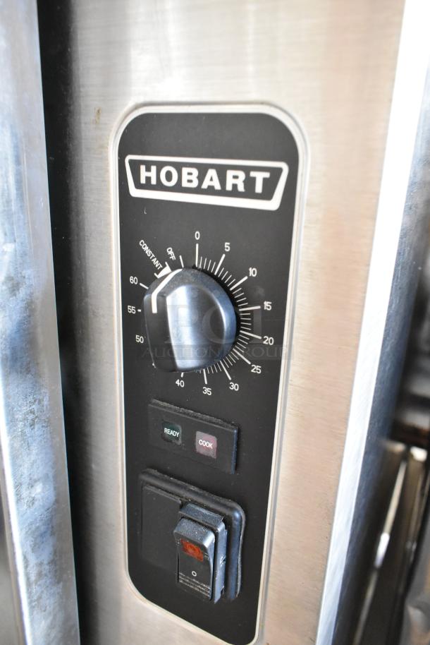 Hobart HC24EA5 stainless steel steam cabinet control panel with dials and indicator lights, showing brand and model.
