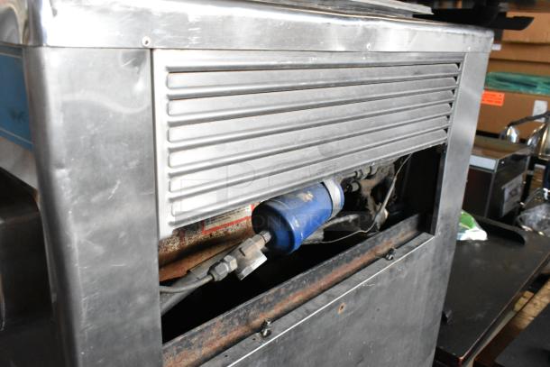 Taylor 754-27 stainless steel 2-flavor soft serve ice cream machine on commercial casters, visible wear on surface.