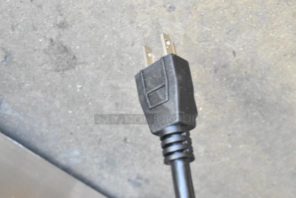 Close-up of a power plug of a Vita-Mix VM0805B mixer, showing a standard prong connector.