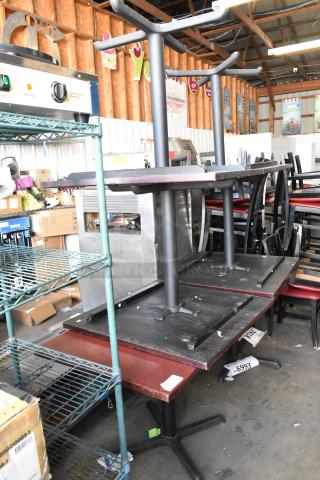 Six dining height tables, black bases, wooden tops, used condition. Tags show lot number "6993" for auction tracking.