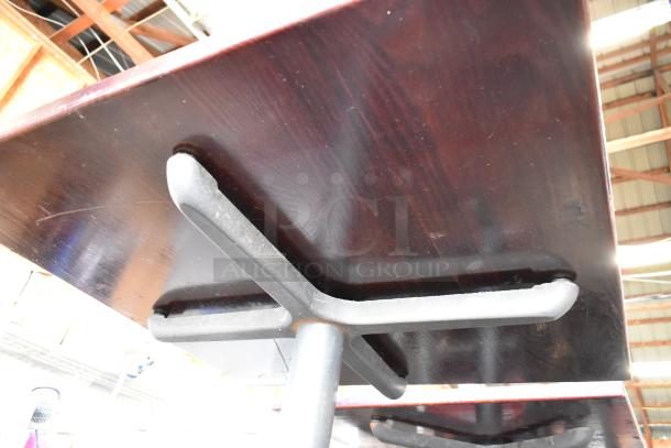 6 dining height tables with dark wood tops and metal bases, showing moderate wear. Auction offers 6 times your bid.
