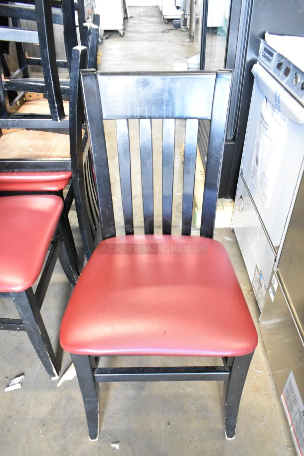 Black dining chair with red seat cushion, slatted back, and four sturdy legs. Auction for 14 chairs. Good condition.