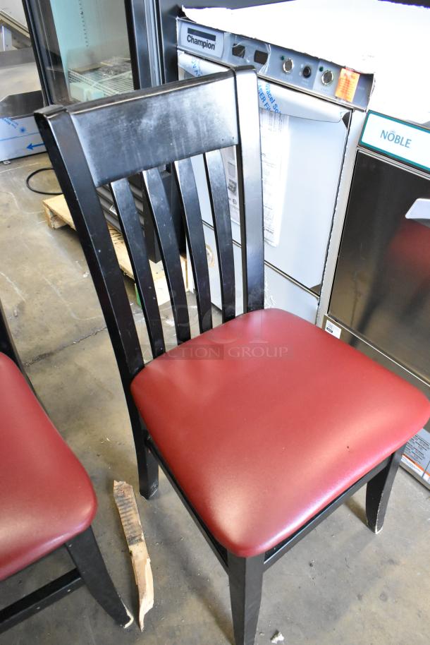 Black dining chair with slatted back and red seat cushion, shown in good condition. Auction includes 14 identical chairs.
