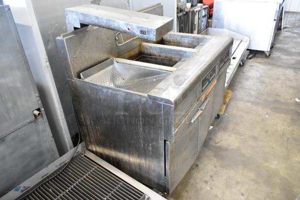 Frymaster FMPH255CSC stainless steel commercial deep fryer with 2 bays, natural gas, filtration system, and dumping station on casters.