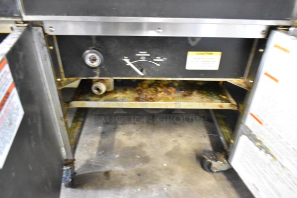 Giles EOF-24 stainless steel electric fryer, 2 bays, center dumping, on commercial casters, 480V, 3 phase, used condition.