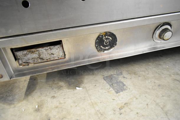 Vulcan stainless steel commercial griddle with thermostatic controls, countertop model, showing wear, adjustable temperature dial.