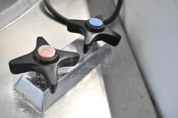 Close-up of the control handles of a Garland KT40S-M 40-gallon stainless steel commercial steam kettle.