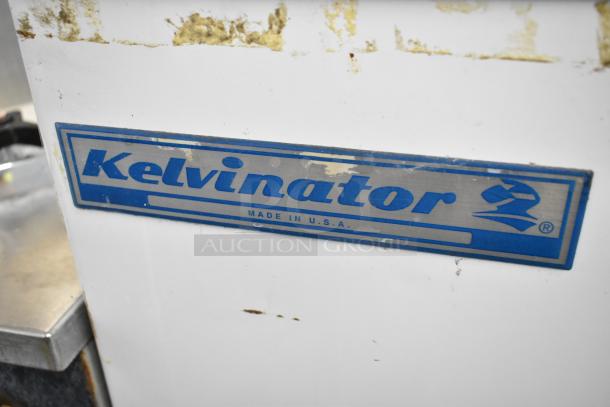 Kelvinator metal commercial chest freezer, 115 volts, 1 phase, on casters, "Made in USA" label visible, moderate wear.