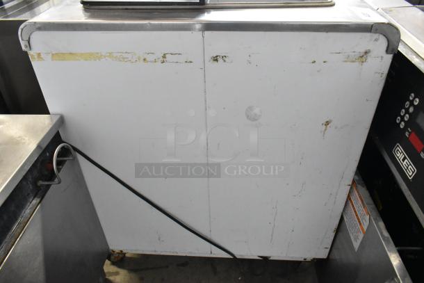 Kelvinator commercial chest freezer on casters, 115V, 1 phase. Visible wear and stickers, metal exterior.