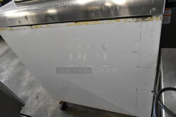 Kelvinator metal commercial chest freezer on casters, 115 volts, 1 phase, with visible wear on the surface edges.