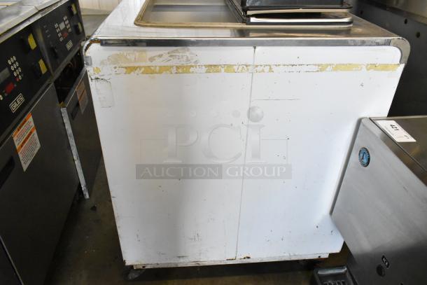 Kelvinator metal commercial chest freezer on casters, 115 volts, 1 phase, shows wear and scratches.