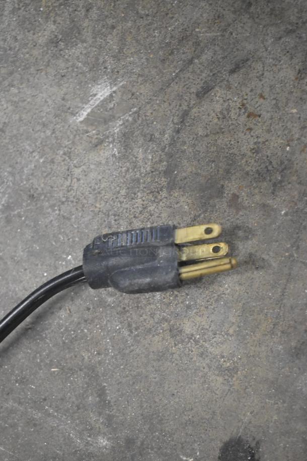 Power plug of Halsey Taylor commercial water fountain, 115 volts, 1 phase, showing three-prong end on textured surface.