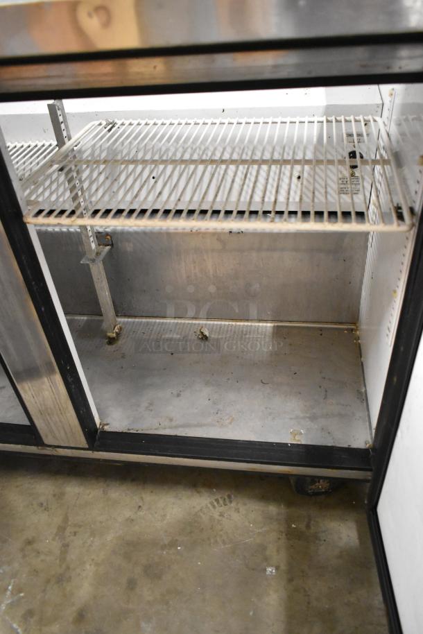 True TSSU-48-12 stainless steel sandwich prep table with wire shelving, commercial casters, and some wear visible.