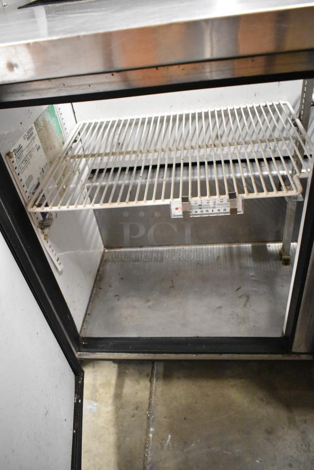 True TSSU-48-12 stainless steel sandwich prep table, features commercial casters, interior shelving, and a visible label.