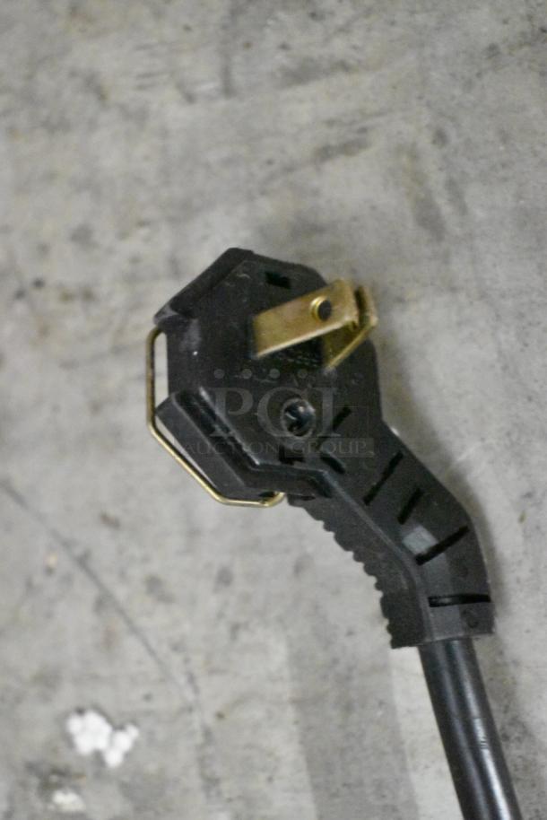Close-up of Manitowoc QY0214A ice machine power plug, showing black and brass elements.